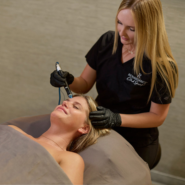 An esthetician doing a Hydrafacial spa treatment at R Spa